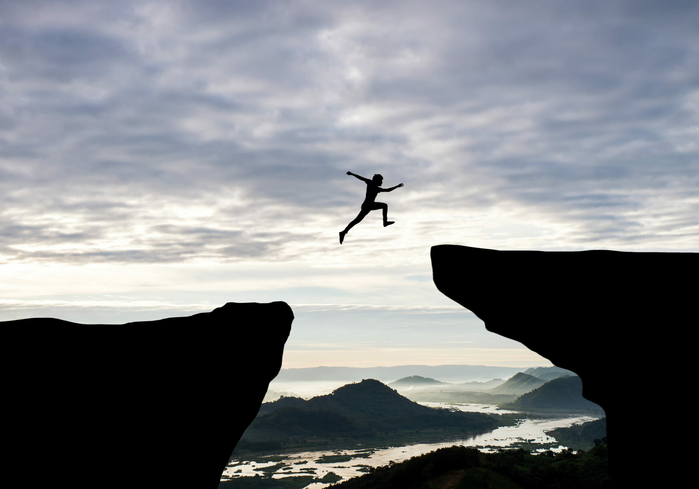Man,Jump,Through,The,Gap,Between,Hill.man,Jumping,Over,Cliff