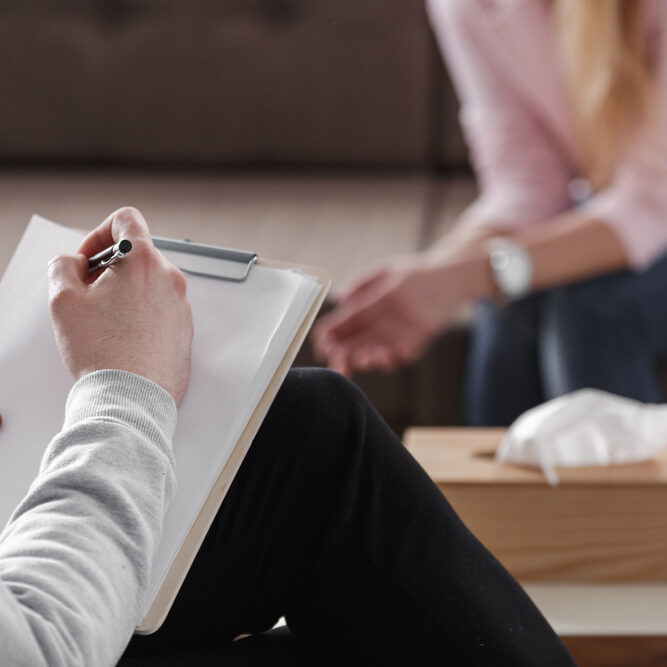 Close-up,Of,Therapist,Hand,Writing,Notes,During,A,Counseling,Session